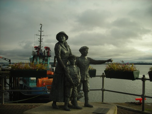 This is a statue of Annie Moore and her two younger brothers. The fifteen-year-old girl was the first person to ever go through Ellis Island, after departing from Cobh. 